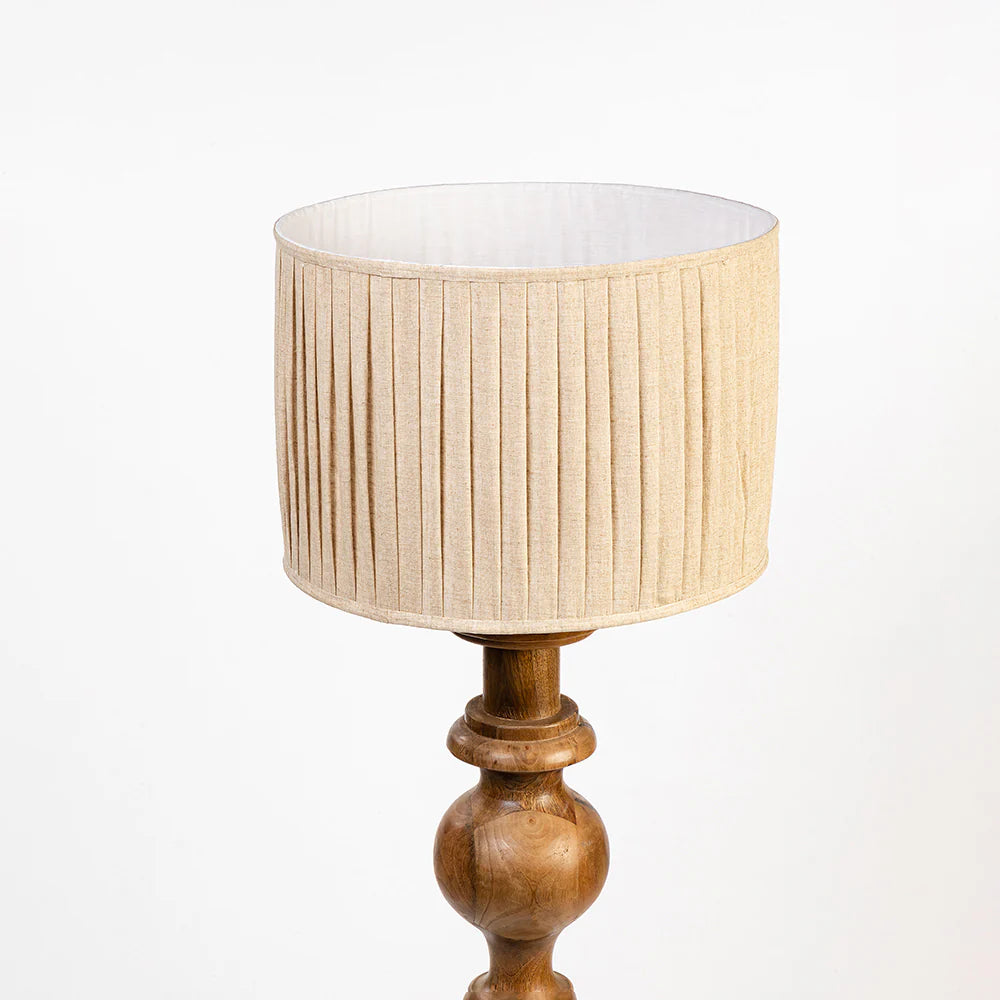 Lamp with wooden base and beige pleated shade on a white background