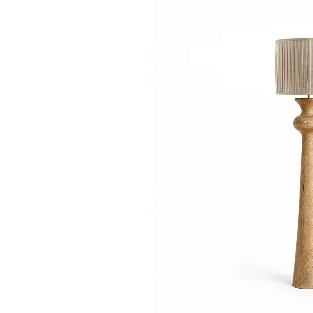 Table lamp with a textured base and pleated shade on a white background